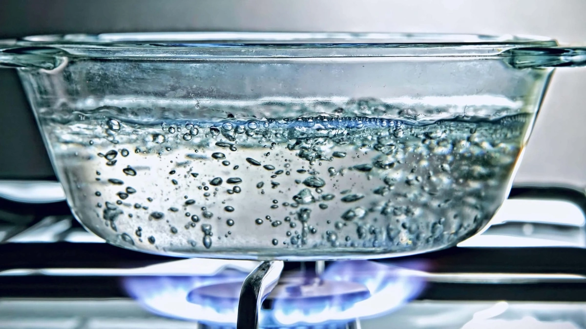 Why does water form bubbles on a stove but not in a microwave?
